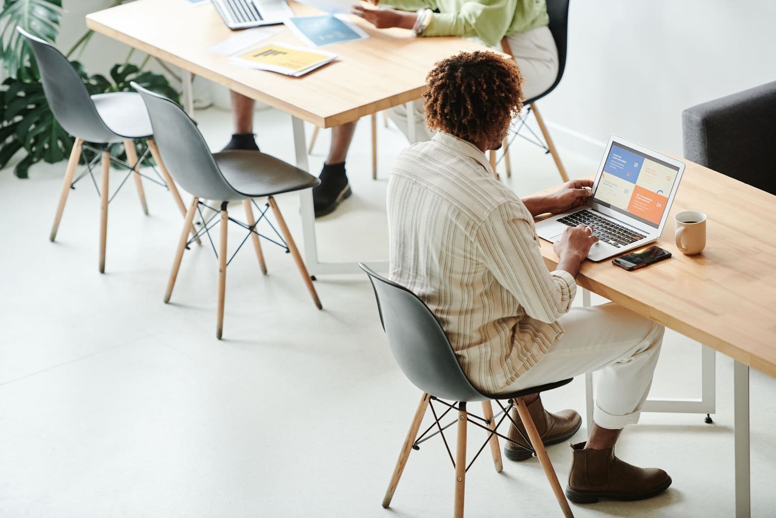 Une équipe au travail dans un bureau lumineux, un portable ouvert sur une présentation